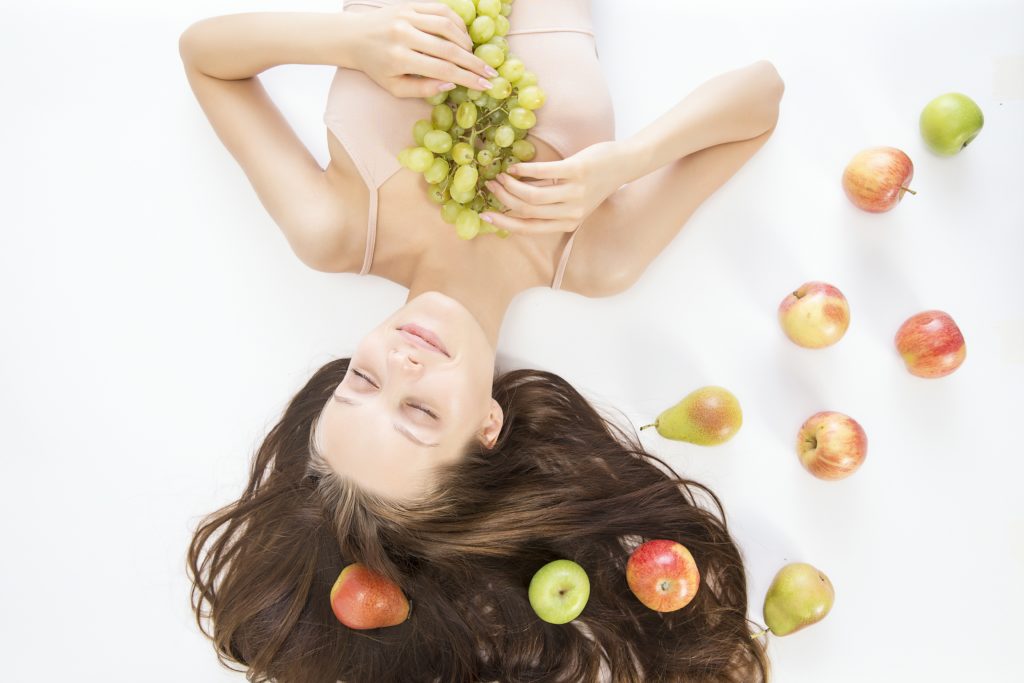 woman laying down with various fruits